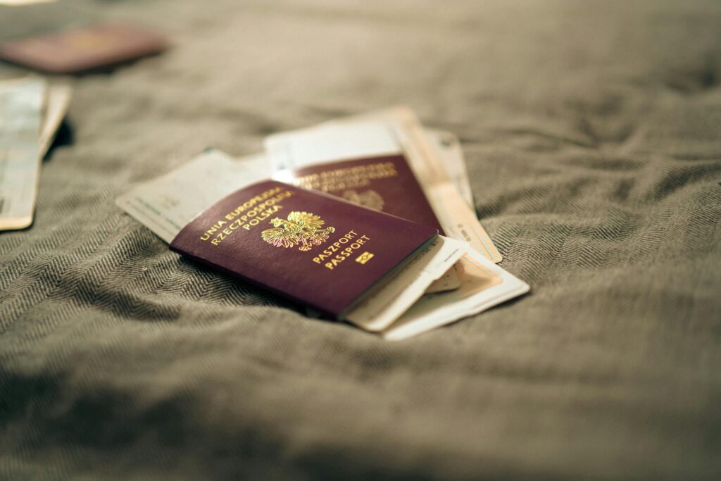 A close-up of a Polish passport and travel documents placed on a fabric surface, symbolizing travel and identity.
